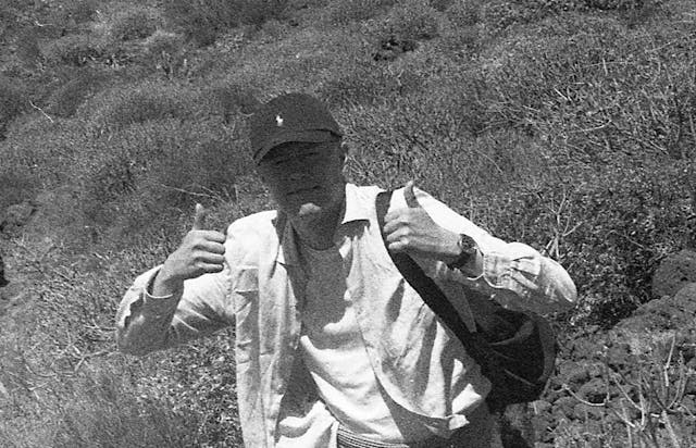 Black and white photo of myself giving thumbs-up outdoors